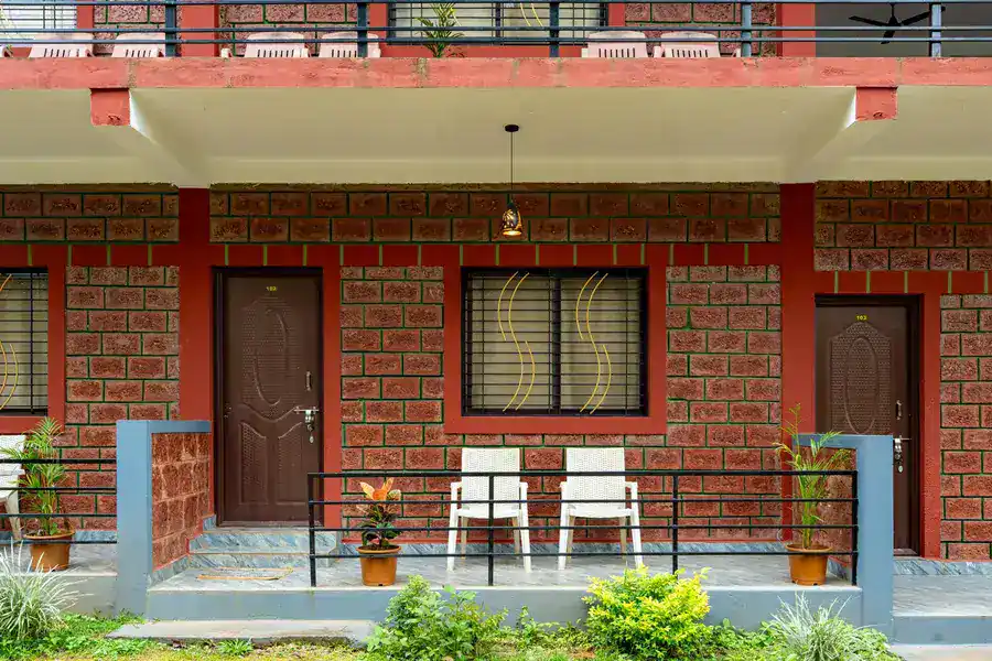 Comfortable room with private veranda overlooking lush gardens at Tusker Trails